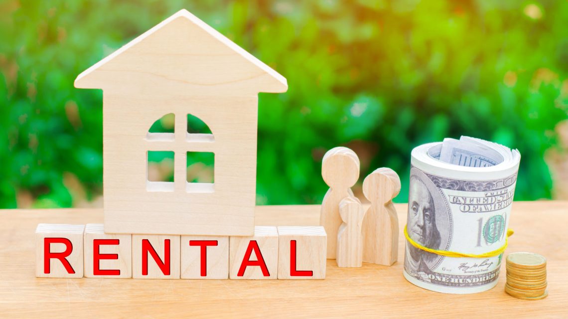 Wooden property model with people discussing investment opportunities in the top rental yield suburbs in Australia for 2025.