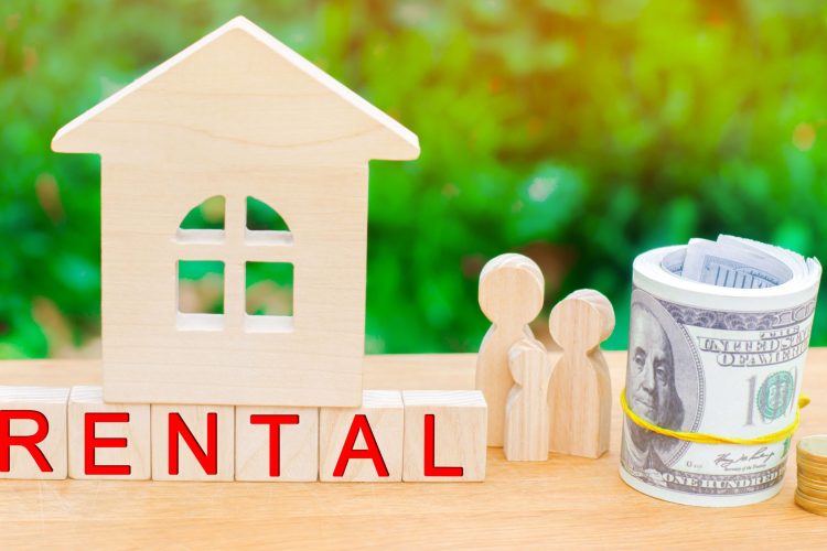 Wooden property model with people discussing investment opportunities in the top rental yield suburbs in Australia for 2025.